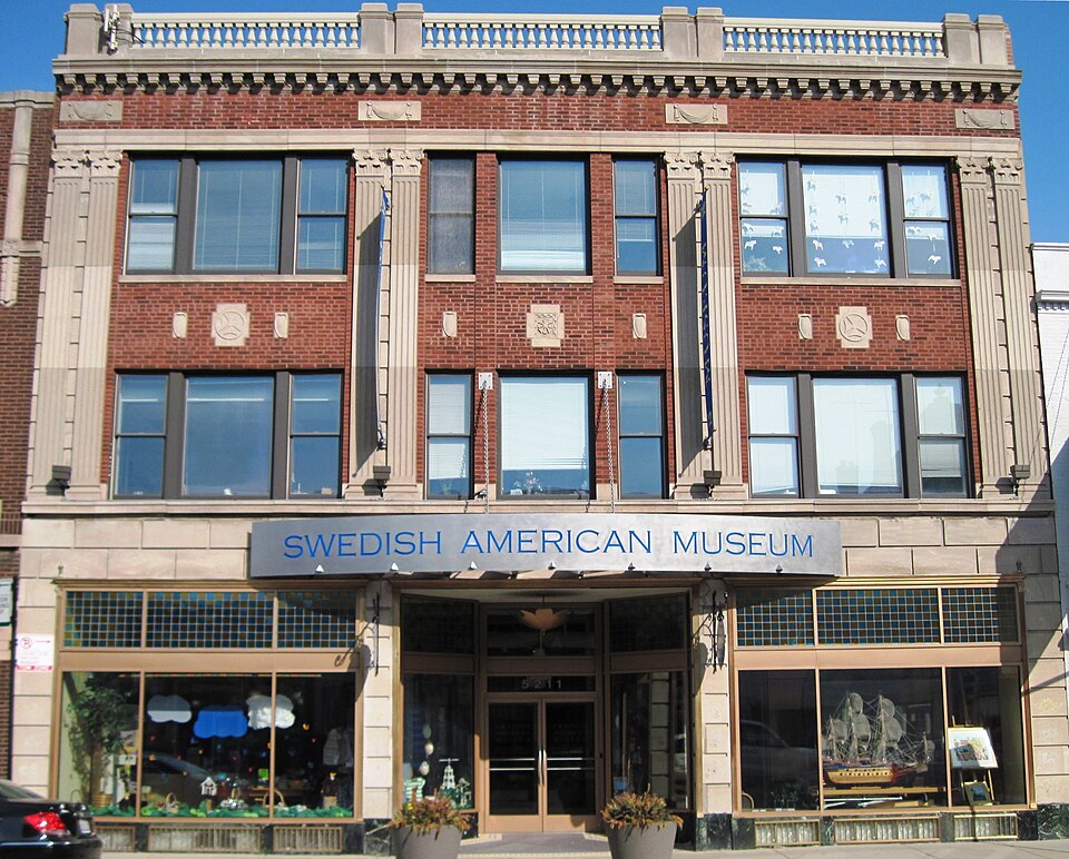 a handsome brick and stone building, three storeys tall, with decorations in the windows